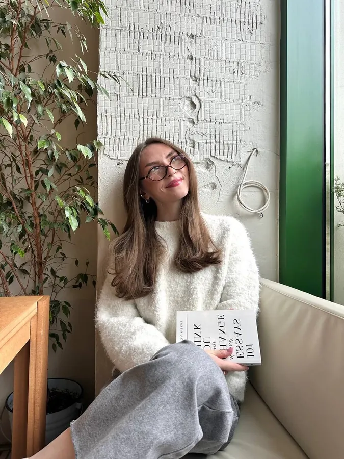 Соня с книгой эссе в светлом кафе